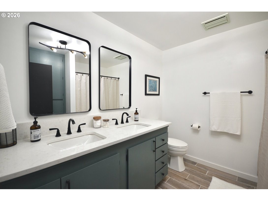 10854 Summit Loop Road Southeast Turner, OR 97392 - Photo 20 of 35 a bathroom with a double vanity sink toilet and mirror