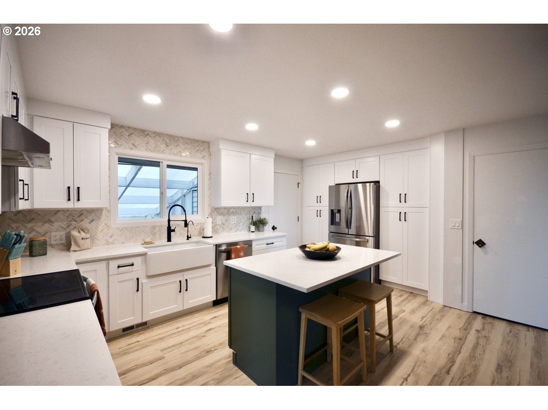 10854 Summit Loop Road Southeast Turner, OR 97392 - Photo 10 of 35 a kitchen with a sink a stove a refrigerator and white cabinets