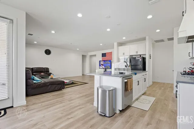a kitchen with stainless steel appliances kitchen island granite countertop a refrigerator and a stove top oven