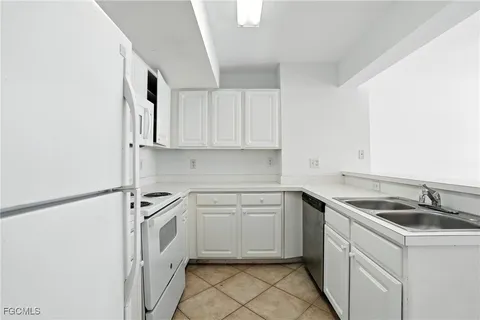 a kitchen with white cabinets and white appliances