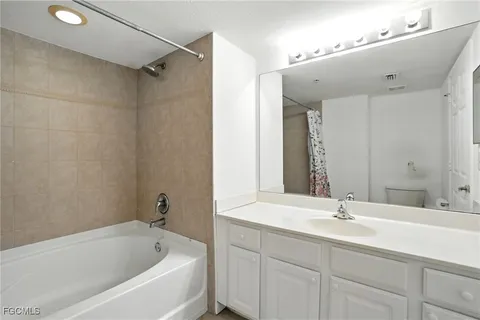 a bathroom with a tub a sink and mirror