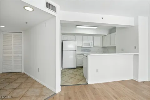 a kitchen with white cabinets and white appliances