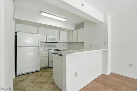 a kitchen with a refrigerator sink stove and cabinets