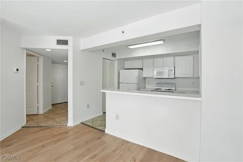 a room with stainless steel appliances granite countertop a sink and a refrigerator
