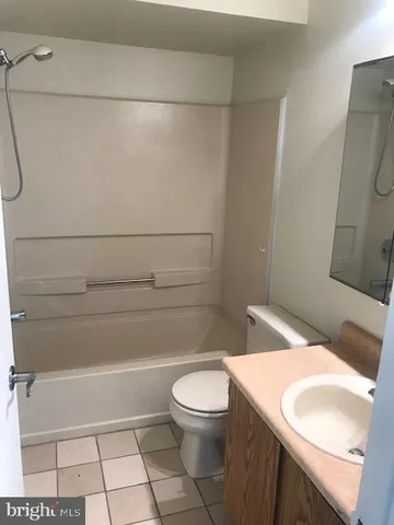 a bathroom with a granite countertop toilet and a sink