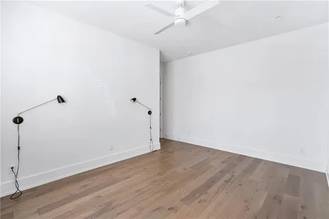an empty room with wooden floor and white walls