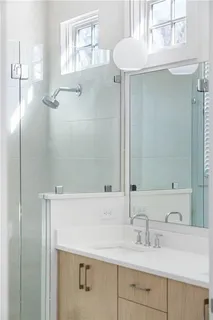 a bathroom with a double vanity sink mirror and shower