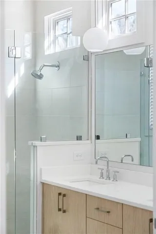 a bathroom with a double vanity sink mirror and shower