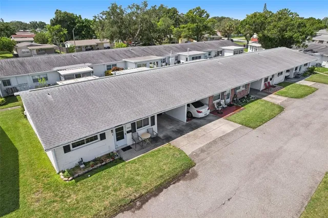 a aerial view of a house with swimming pool and trees in the background