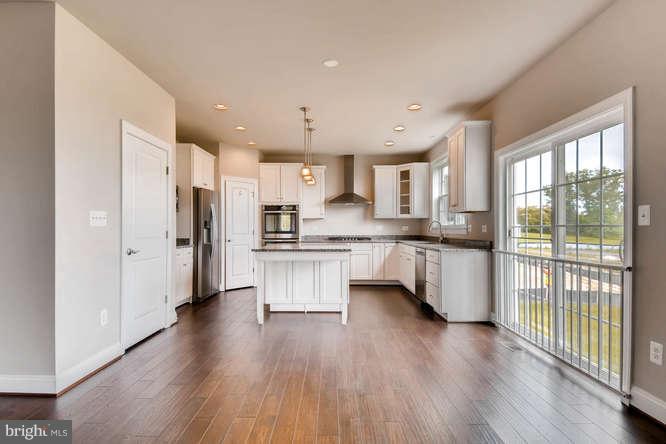 4317 Forge Road Perry Hall, MD 21128 - Photo 5 of 20 a kitchen with stainless steel appliances a refrigerator a sink dishwasher a oven and a dining table with wooden floor