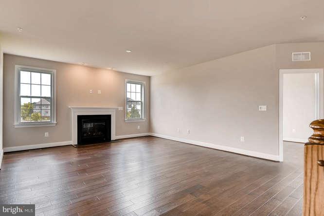 4317 Forge Road Perry Hall, MD 21128 - Photo 8 of 20 an empty room with wooden floor fireplace and windows