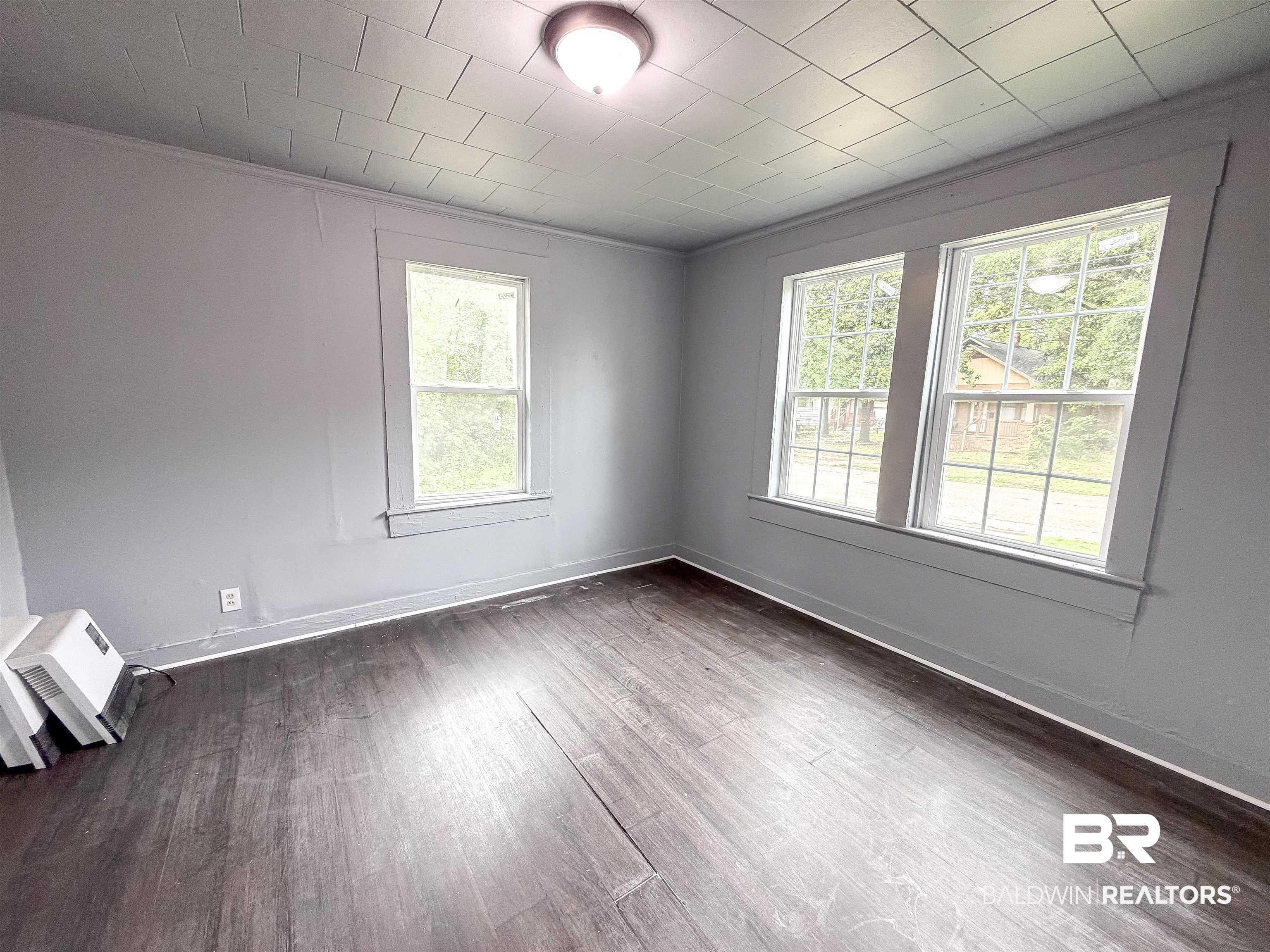 38 Flock Avenue Mobile, AL 36610 - Photo 20 of 27 Room featuring wood-finish flooring, two large windows, a single window, and a ceiling light fixture