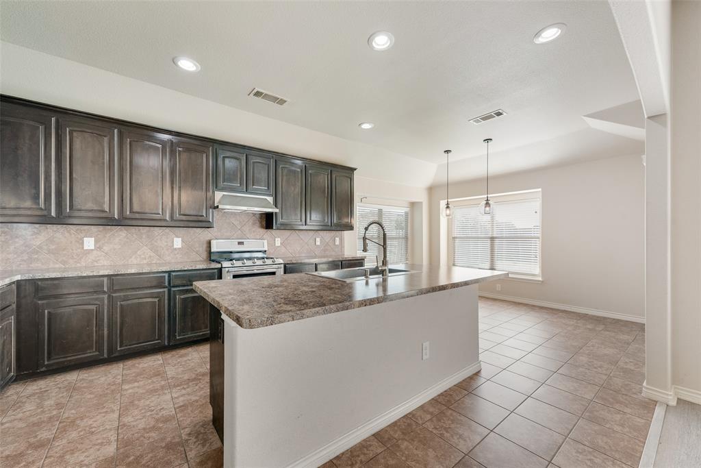 103 Rambling Way Forney, TX 75126 - Photo 13 of 32 a kitchen with stainless steel appliances granite countertop a sink stove and cabinets