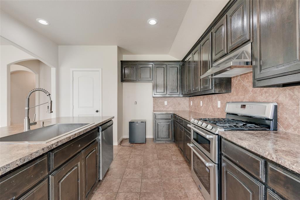 103 Rambling Way Forney, TX 75126 - Photo 15 of 32 a kitchen with stainless steel appliances granite countertop a sink stove and cabinets