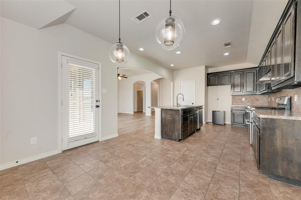 103 Rambling Way Forney, TX 75126 - Photo 18 of 32 a large kitchen with stainless steel appliances kitchen island granite countertop a stove a sink a refrigerator and a view of living room