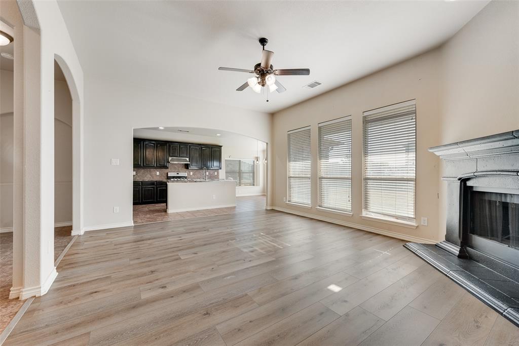 103 Rambling Way Forney, TX 75126 - Photo 9 of 32 a view of an empty room with a kitchen and a fireplace