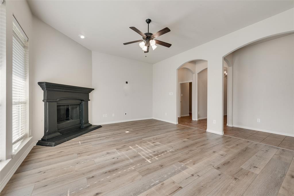 103 Rambling Way Forney, TX 75126 - Photo 10 of 32 an empty room with ceiling fan and a fireplace
