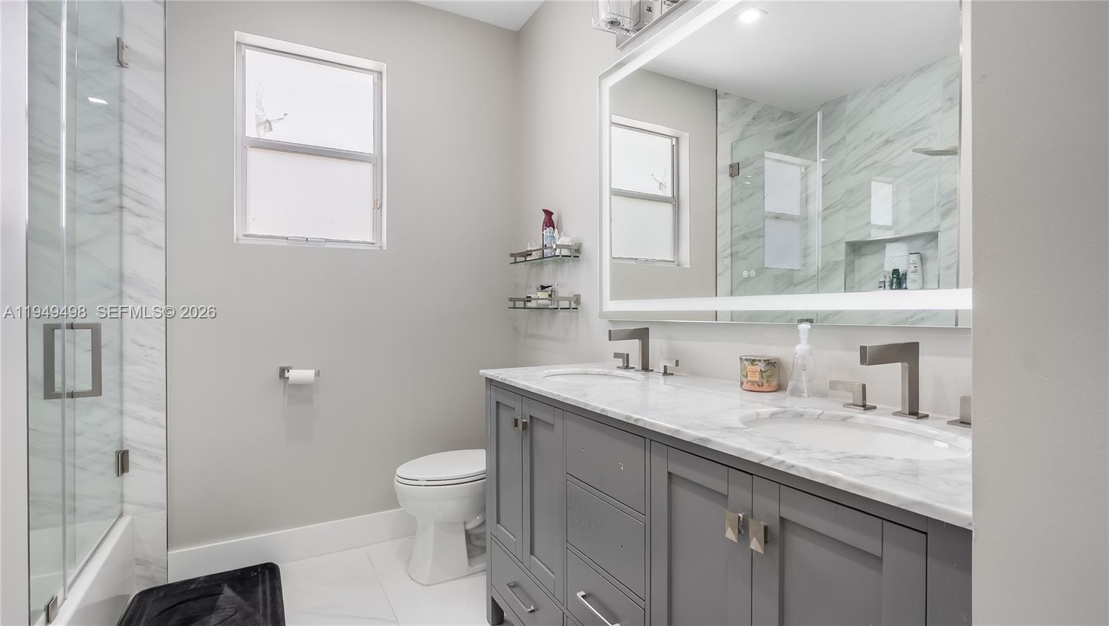 17739 Southwest 54th Street Miramar, FL 33029 - Photo 27 of 47 a bathroom with a granite countertop sink a toilet and shower