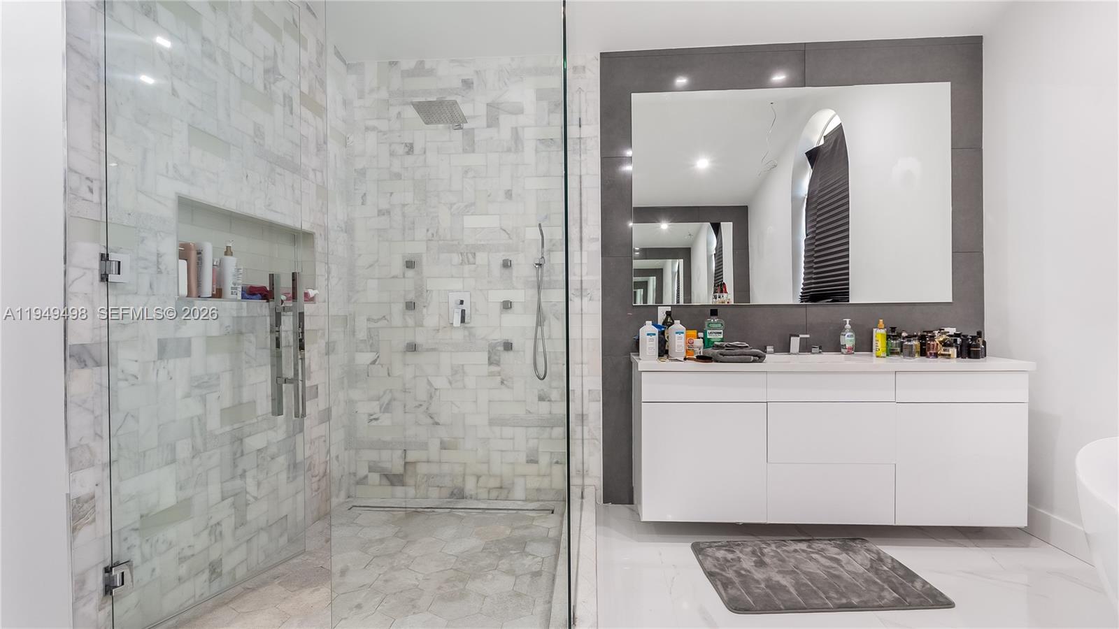 17739 Southwest 54th Street Miramar, FL 33029 - Photo 41 of 47 a bathroom with a sink a mirror and a shower