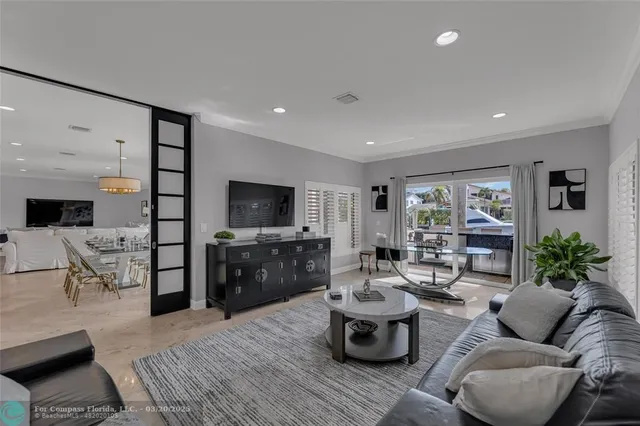a living room with furniture a chandelier and a flat screen tv