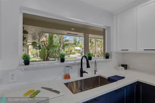 a view of a patio with couches chairs potted plants and wooden floor