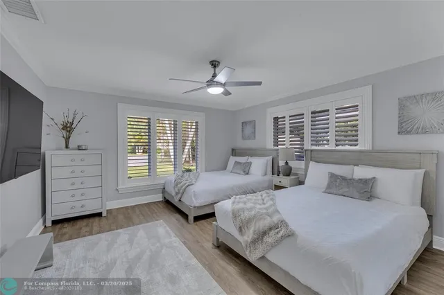 a bedroom with a bed wooden floor and window