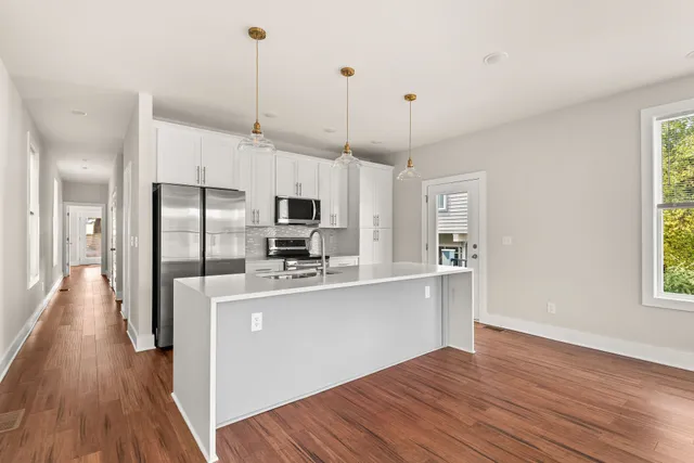 a kitchen with stainless steel appliances a microwave a sink and a refrigerator