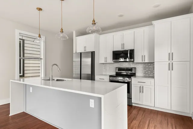 a kitchen with stainless steel appliances granite countertop a sink and a stove