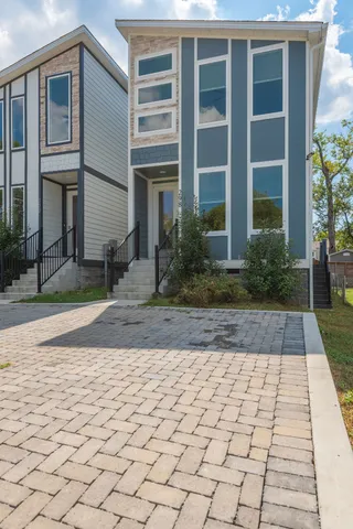 front view of a brick house with a yard