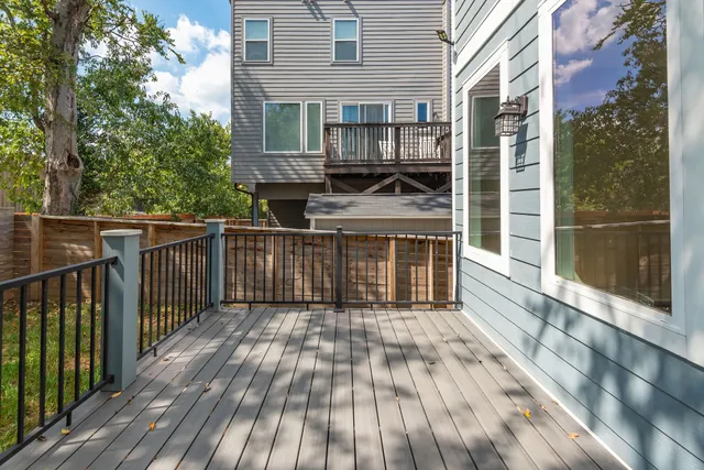 a view of a backyard with large trees and wooden fence