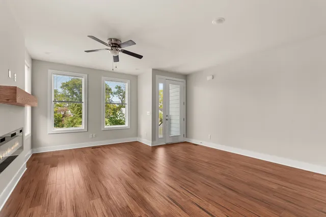 a view of wooden floor fire place refrigerator and window in a room