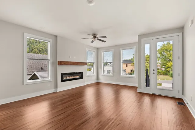 a kitchen with stainless steel appliances a refrigerator a sink dishwasher a stove and white cabinets with wooden floor