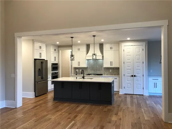 a kitchen with stainless steel appliances granite countertop a refrigerator and a sink