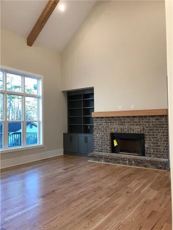 wooden floor fireplace and windows in an empty room