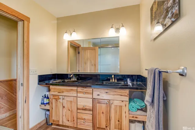 a bathroom with a granite countertop sink and a mirror