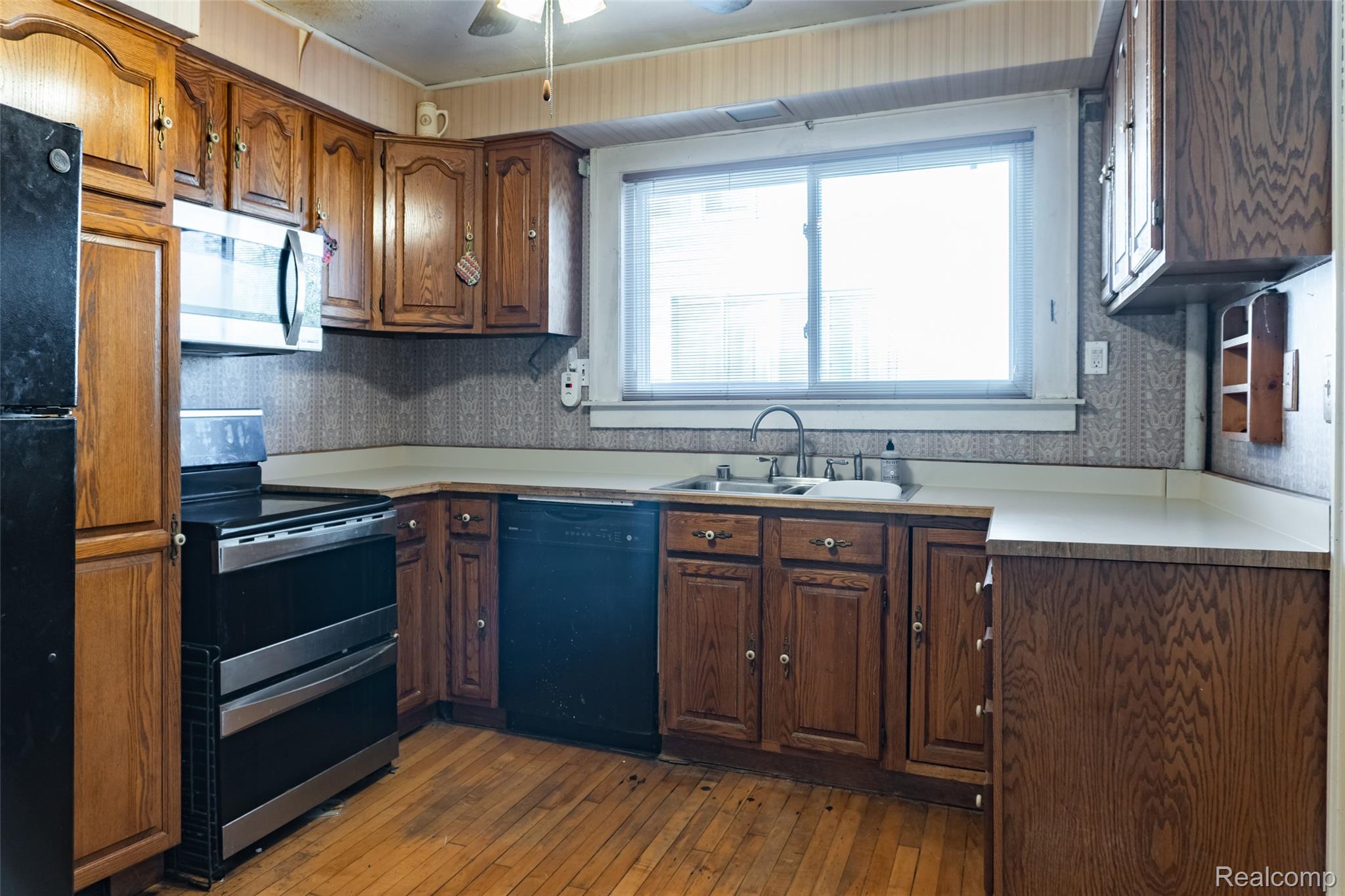 1846 North Gulley Road Dearborn, MI 48128 - Photo 4 of 32 Kitchen with black appliances, dark wood-style flooring, light countertops, brown cabinets, and ceiling fan