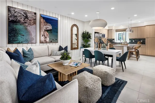 a living room with furniture kitchen view and a large window