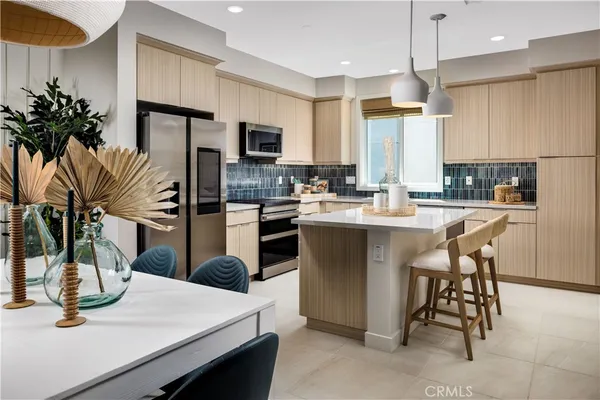 a kitchen with sink a refrigerator and chairs
