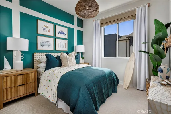 a bedroom with a bed a mirror on the dresser and a large window