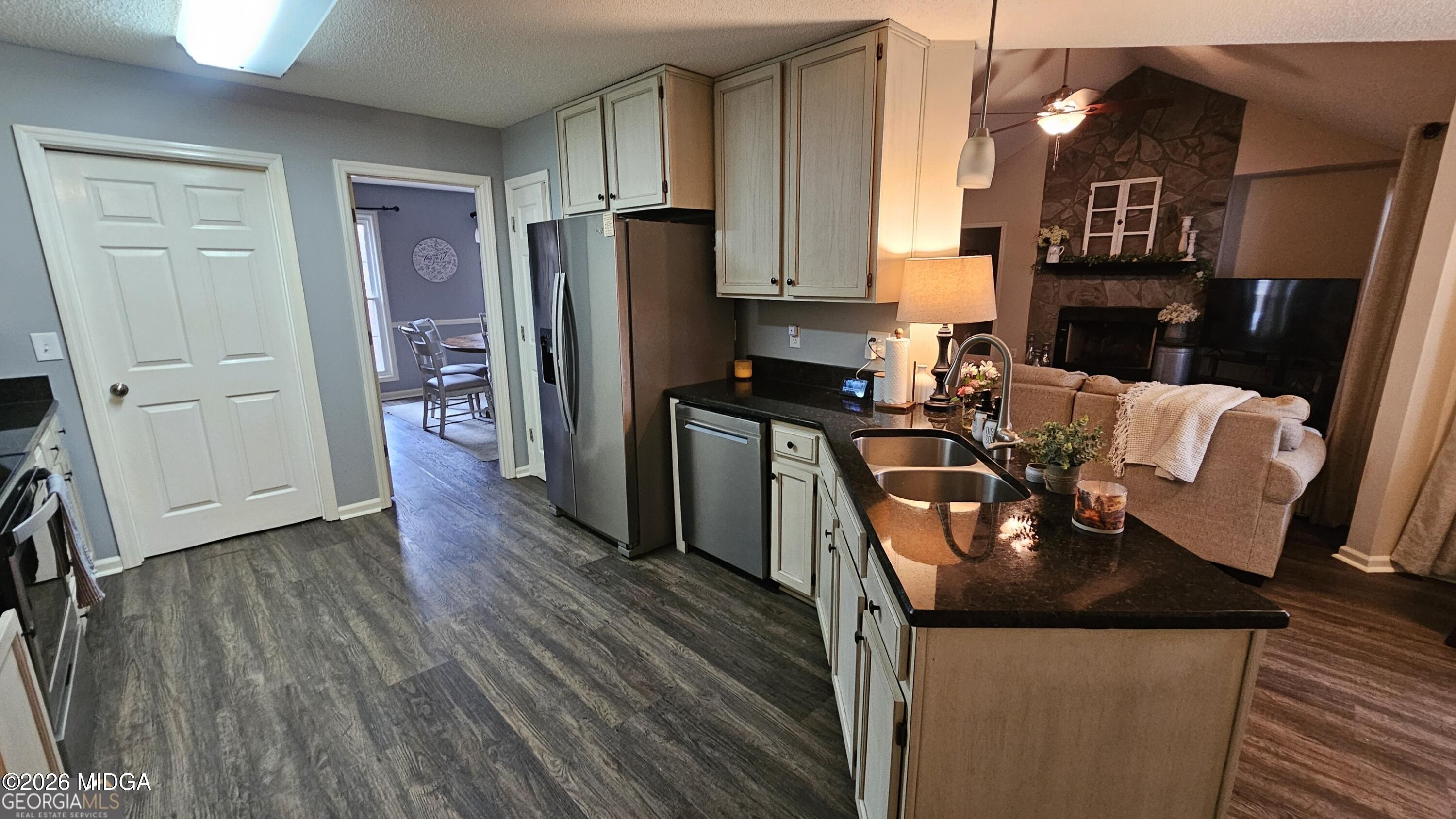 306 Lakeridge Court Macon, GA 31211 - Photo 7 of 14 a kitchen with stainless steel appliances granite countertop a refrigerator a stove top oven a sink dishwasher and wooden floor