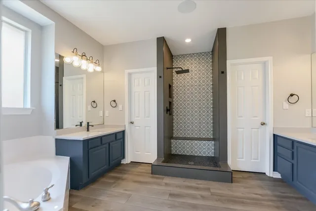 a bathroom with a double vanity sink mirror and shower