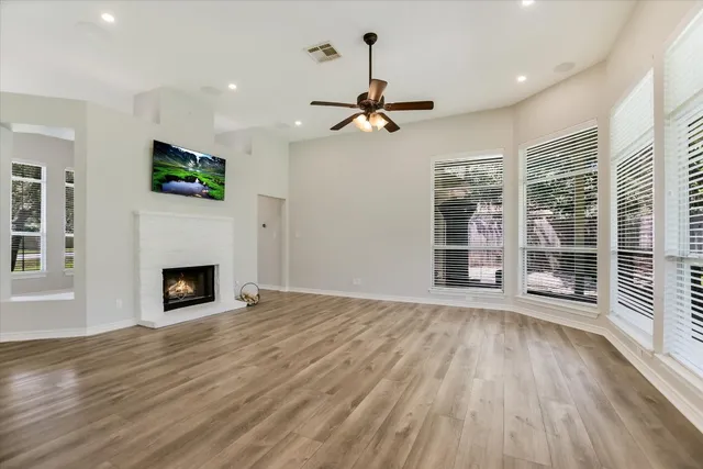 a view of a livingroom with wooden floor a fireplace a window and a fireplace