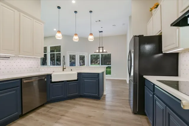 a kitchen with stainless steel appliances granite countertop a sink a stove and a refrigerator