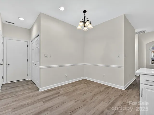 an empty room with wooden floor and ceiling fan