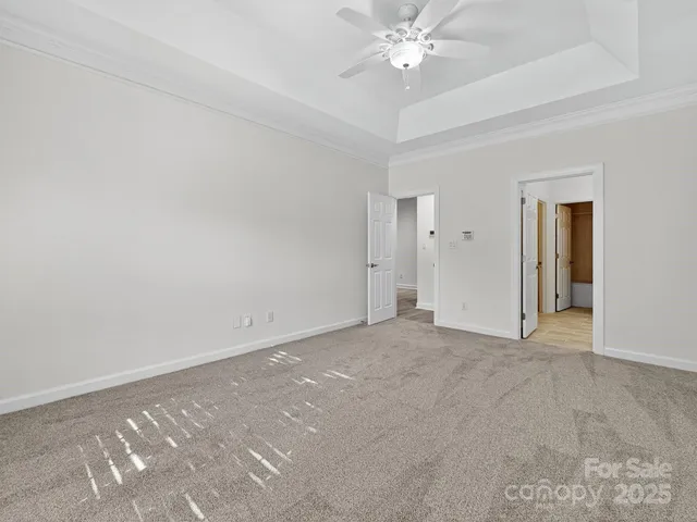 a view of an empty room with a chandelier fan
