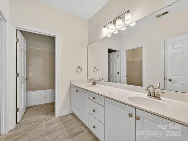 a spacious bathroom with a double vanity sink double and mirror