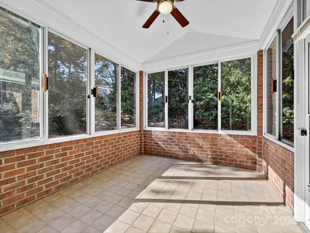 a view of an empty room with wooden floor and a fireplace