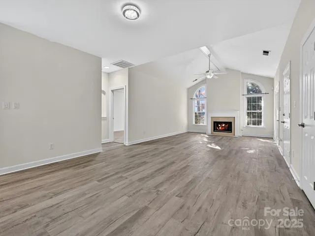 an empty room with wooden floor and a fireplace