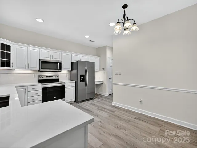 a kitchen with granite countertop a refrigerator stove and microwave