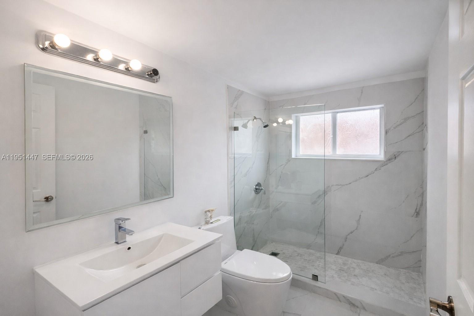 236 Northeast 55th Terrace, Unit 236 Miami, FL 33137 - Photo 3 of 10 a bathroom with a sink a toilet and shower